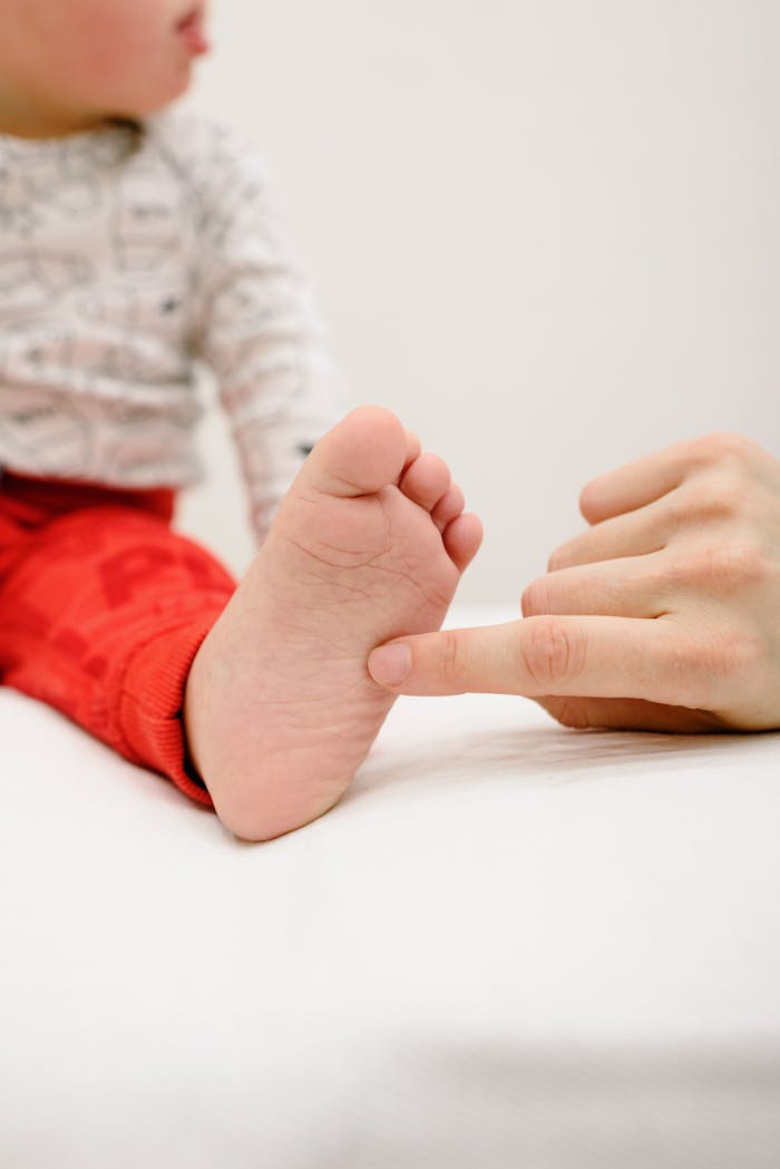 Close-up of baby foot being gently massaged, highlighting tender care.